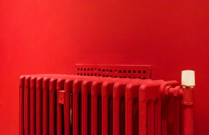 Radiador de hierro pintado de rojo, ejemplo de equipo a revisar durante el mantenimiento de radiadores en verano